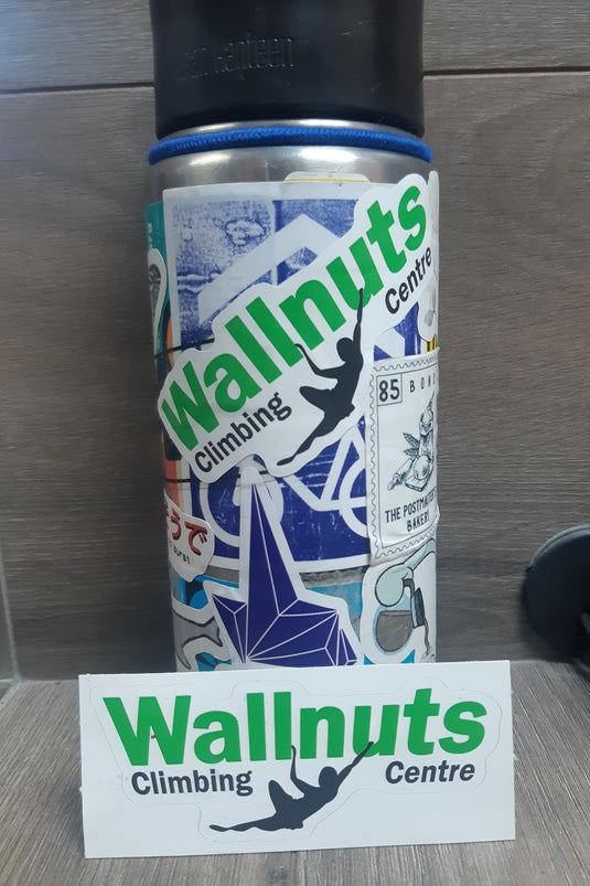 'Wallnuts Climbing Centre' brand logo stickers, shown on their backing paper and placed on a sticker-covered coffee thermos.